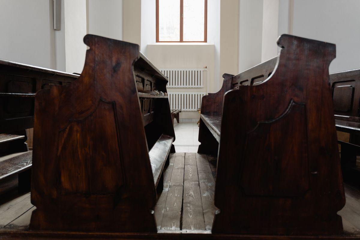 Empty wooden pews in a quiet, sunlit church